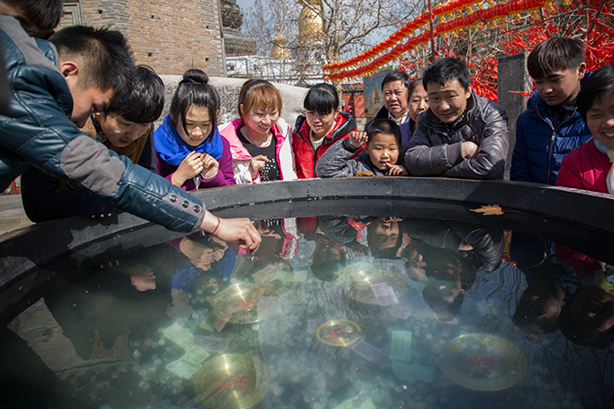 拍摄于汶上宝相寺，人们往大缸里抛钱币祈福。。
